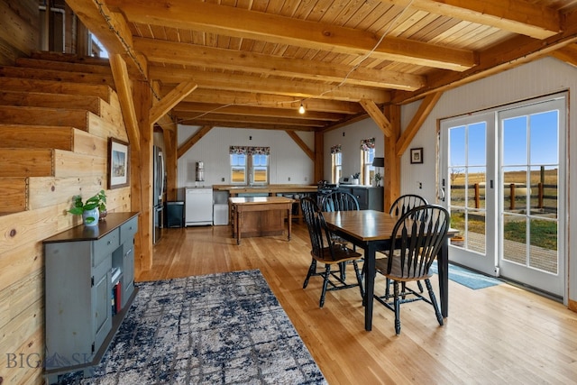 dining room featuring light hardwood / wood-style floors, a wealth of natural light, wooden ceiling, and beam ceiling