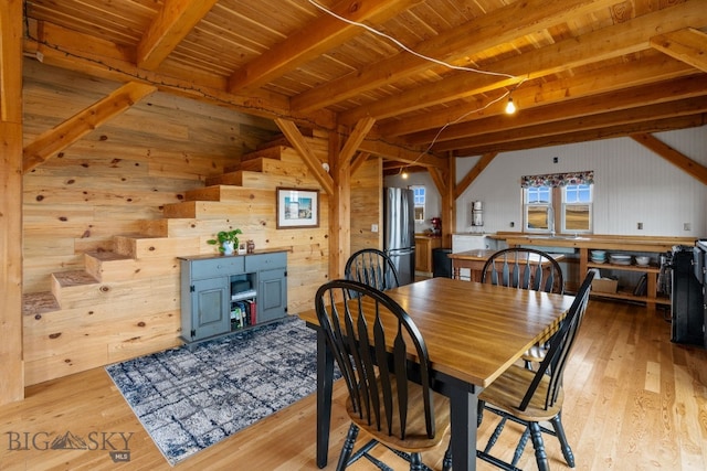 dining space with wood walls, light hardwood / wood-style floors, and wooden ceiling