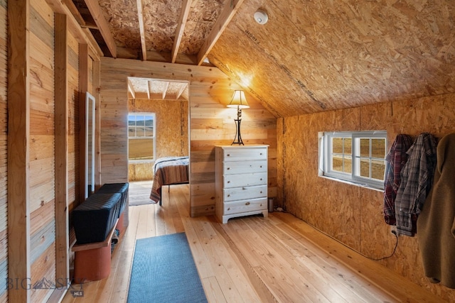 bonus room featuring wooden walls, lofted ceiling, and light wood-type flooring