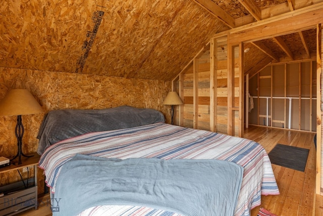 bedroom featuring hardwood / wood-style floors and lofted ceiling