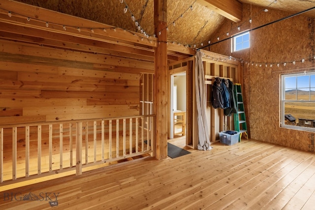 interior space featuring light wood-type flooring, high vaulted ceiling, beamed ceiling, and a healthy amount of sunlight