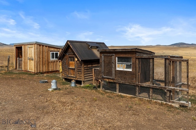 view of side of property featuring a storage unit and a mountain view