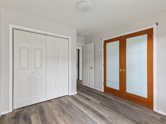 unfurnished bedroom with a closet, hardwood / wood-style flooring, and french doors