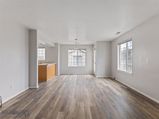 unfurnished living room with hardwood / wood-style floors and a healthy amount of sunlight