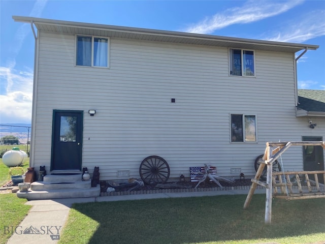 rear view of property with a yard