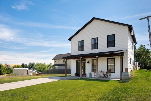 back of house featuring covered porch and a yard