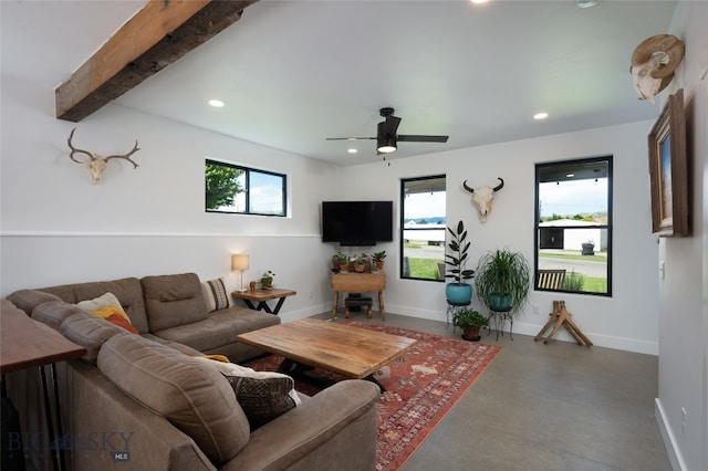 living room with ceiling fan, beamed ceiling, and concrete floors