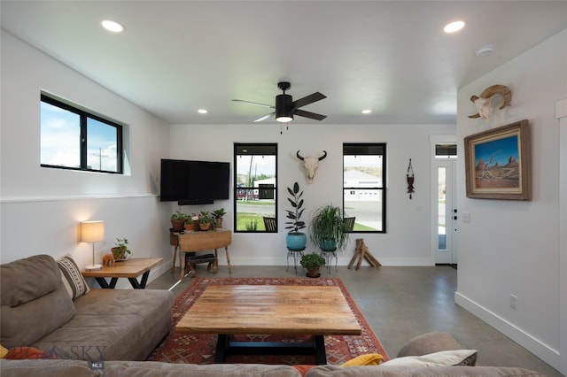 living room featuring ceiling fan and concrete flooring