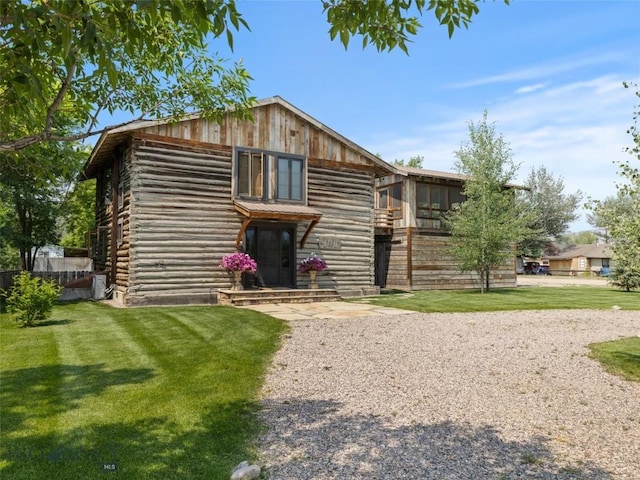 view of front facade featuring a front yard and log siding