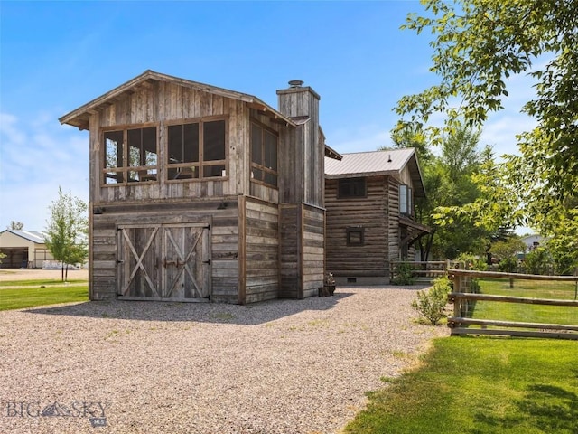 exterior space with an outbuilding, gravel driveway, and an attached garage