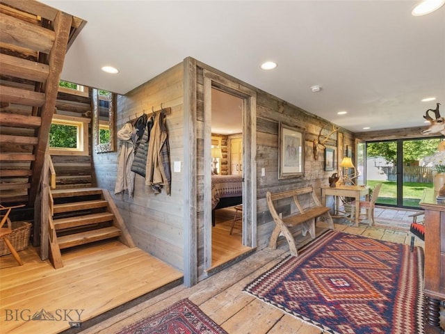 interior space with a healthy amount of sunlight, wood-type flooring, wooden walls, and recessed lighting