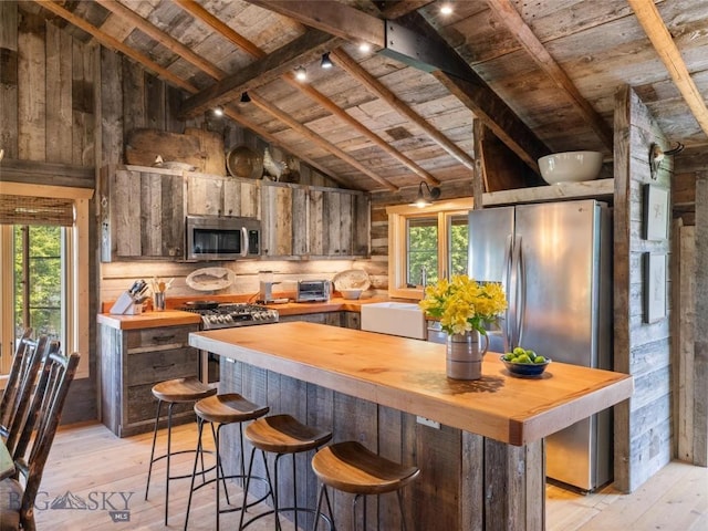 kitchen featuring stainless steel appliances, wood ceiling, a sink, wood counters, and light wood-type flooring