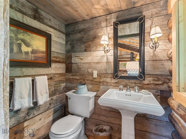 bathroom with toilet, wooden ceiling, and wooden walls