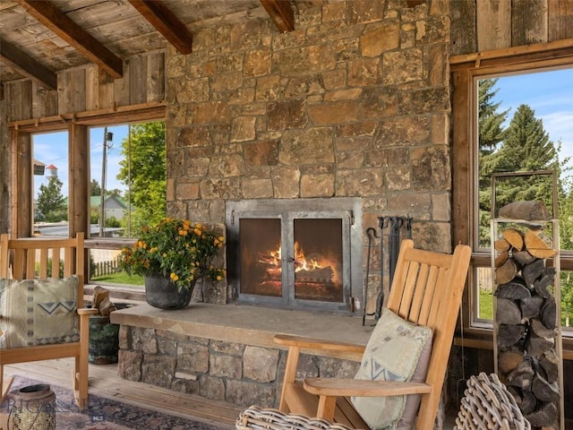 exterior space featuring wood ceiling, an outdoor stone fireplace, beamed ceiling, and wood finished floors