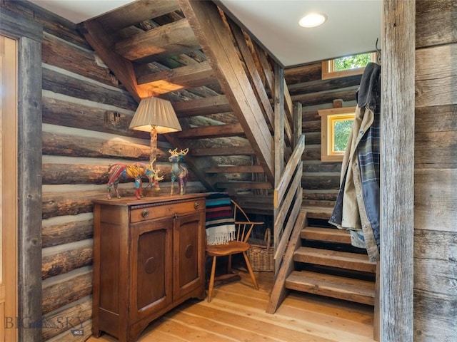 stairs with rustic walls, hardwood / wood-style flooring, and recessed lighting