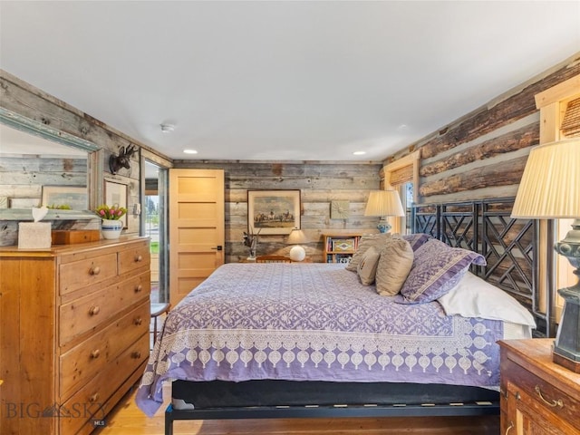 bedroom featuring recessed lighting, log walls, and wood finished floors