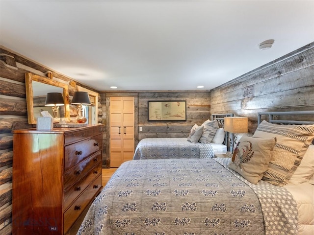 bedroom with rustic walls, light wood-style flooring, and recessed lighting