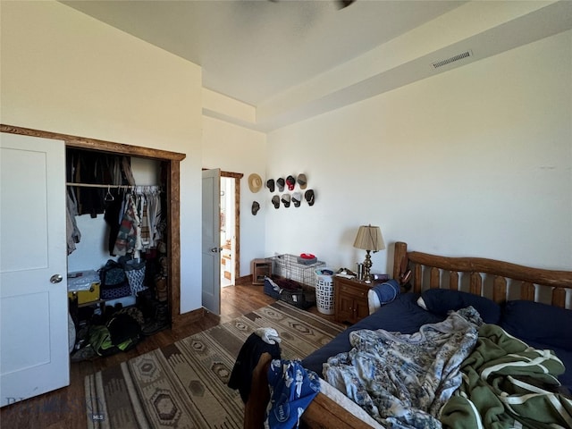 bedroom with dark wood-type flooring and a closet