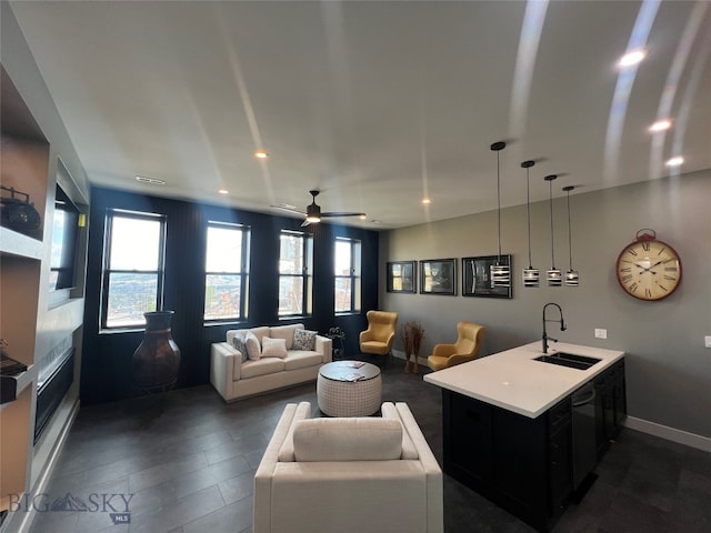 living room with ceiling fan, dark hardwood / wood-style floors, and sink