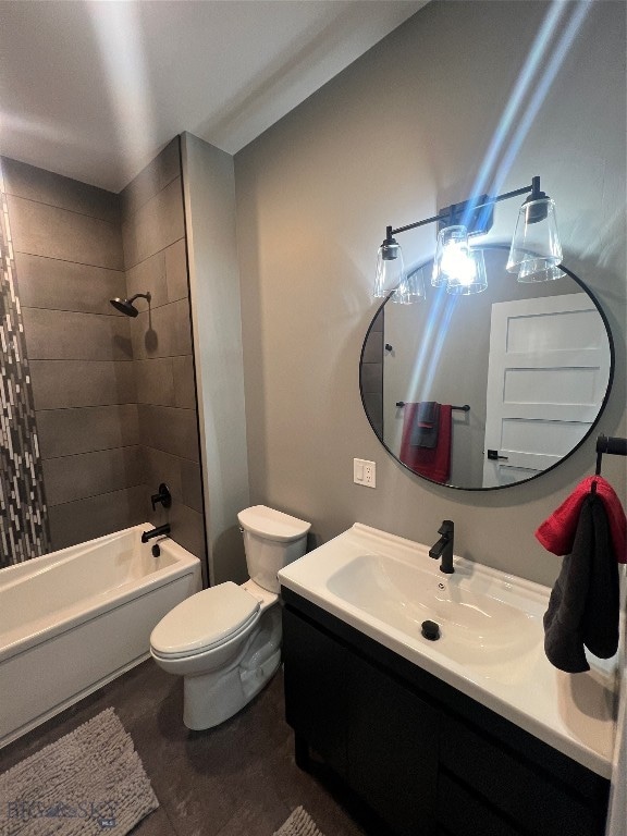 full bathroom featuring tiled shower / bath combo, toilet, and vanity