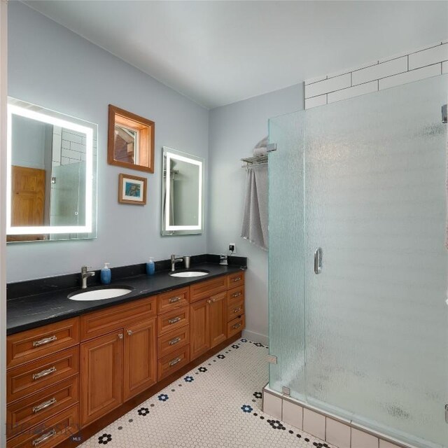 bathroom with tile patterned flooring, vanity, and a shower with shower door