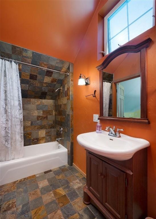 bathroom with vanity, shower / bathtub combination with curtain, and lofted ceiling