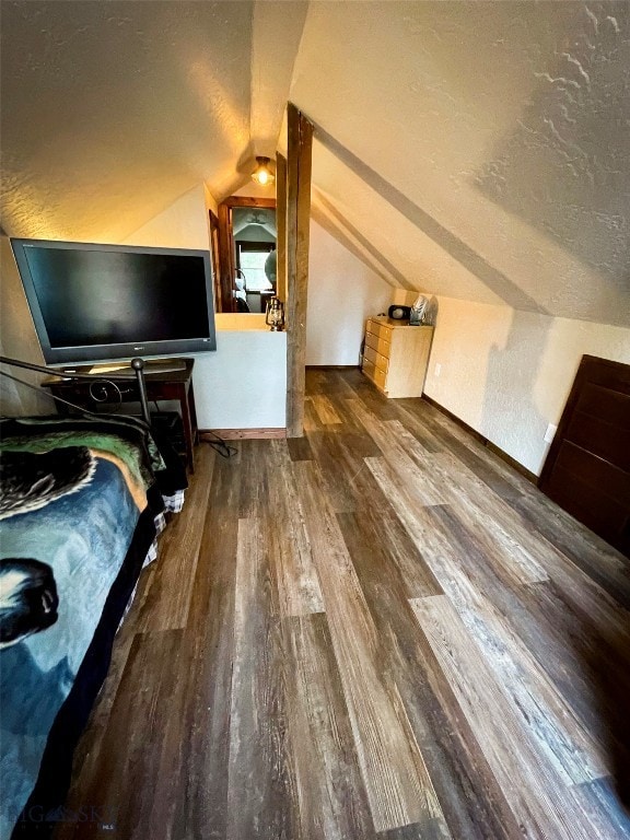 interior space with lofted ceiling, dark wood-type flooring, and a textured ceiling