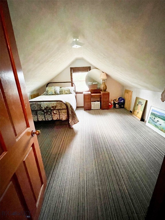 bedroom featuring a textured ceiling and vaulted ceiling