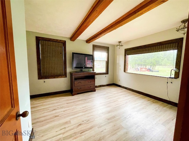 unfurnished living room with light hardwood / wood-style flooring and beamed ceiling