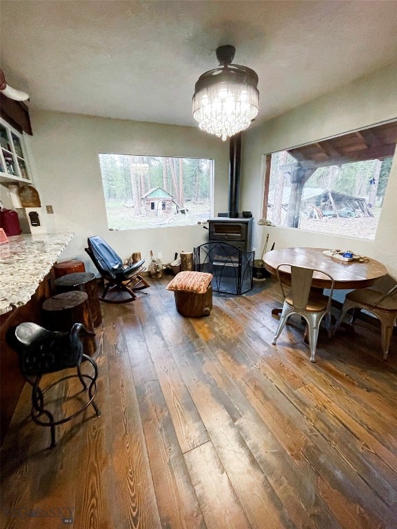 interior space with a wood stove, hardwood / wood-style floors, and a notable chandelier