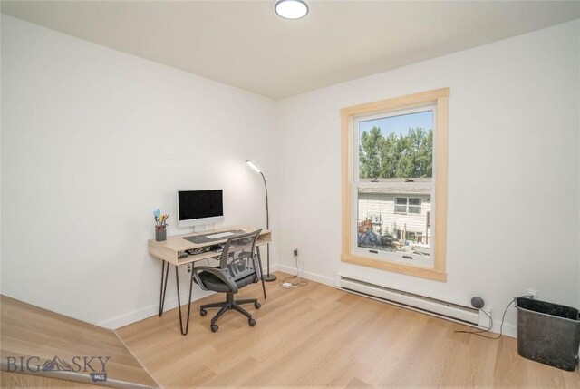 office area with baseboard heating and light hardwood / wood-style flooring