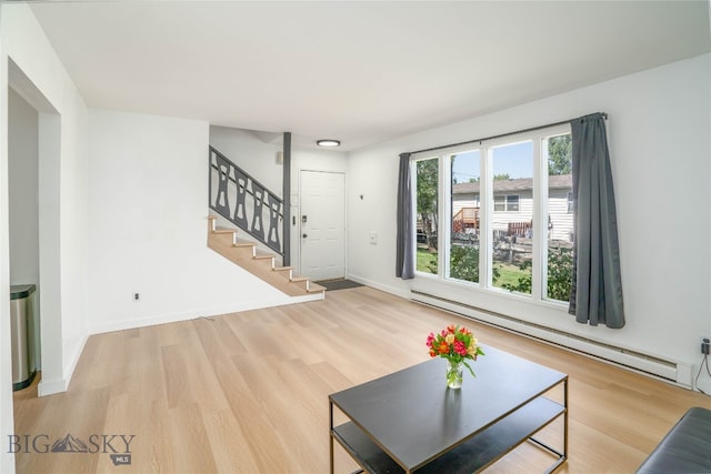 living room with baseboard heating and light hardwood / wood-style flooring