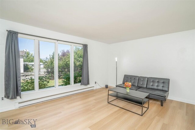 living area with light hardwood / wood-style floors and a baseboard heating unit