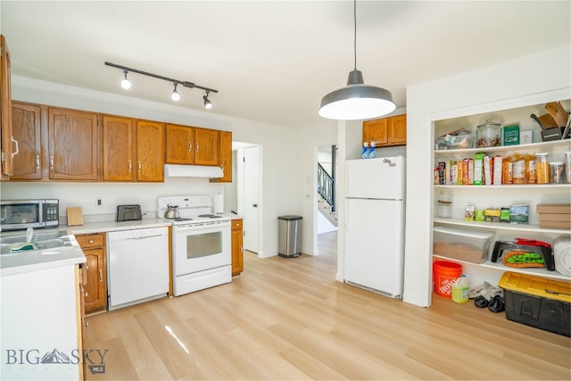 kitchen with light hardwood / wood-style flooring, white appliances, and hanging light fixtures