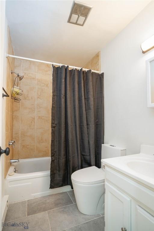 full bathroom featuring toilet, vanity, tile patterned flooring, and shower / bathtub combination with curtain