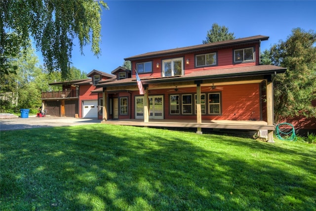 view of front of home featuring a garage, ceiling fan, and a front yard