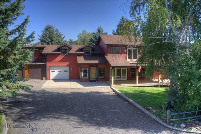 8733 Huffman, Bozeman, MT 59715 - view of front of house with driveway, a deck, a front yard, fence, and a garage