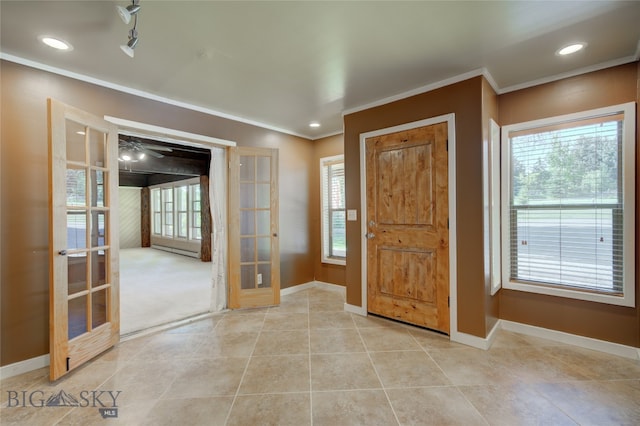 tiled foyer entrance featuring ceiling fan, ornamental molding, and french doors