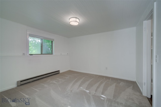 carpeted spare room with a baseboard heating unit