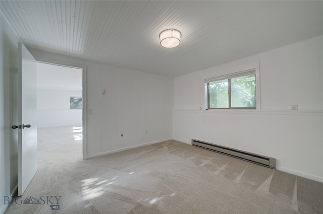 carpeted empty room featuring a baseboard heating unit