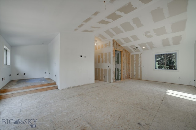 unfurnished living room featuring vaulted ceiling