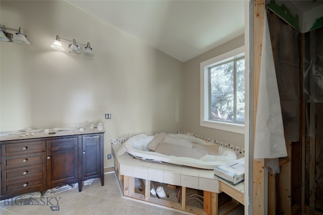 bathroom with a tub, tile patterned flooring, and vanity