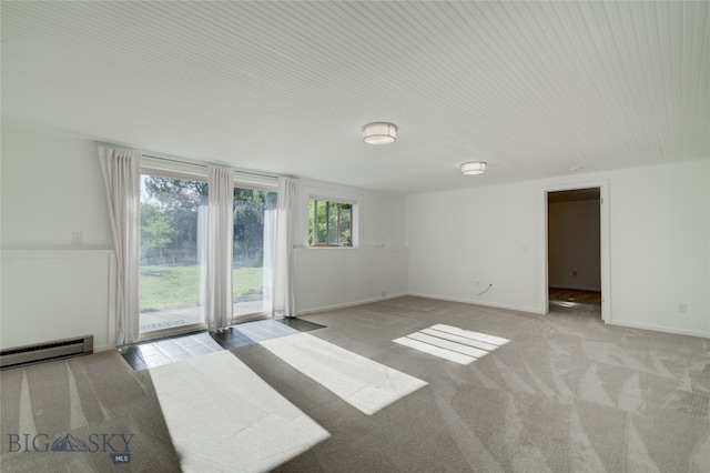 unfurnished room with a baseboard heating unit and light colored carpet