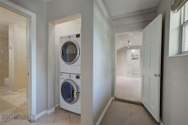 clothes washing area featuring light colored carpet and stacked washer / drying machine