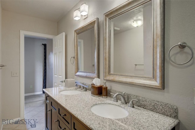 8733 Huffman, Bozeman, MT 59715 - bathroom featuring double vanity, a sink, tile patterned floors, and baseboards