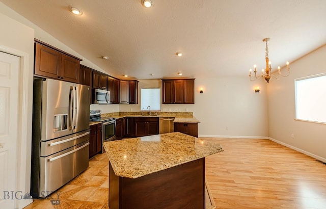 25 Amber, Dillon, MT 59725 - kitchen featuring appliances with stainless steel finishes, a chandelier, a sink, a center island, and light stone counters