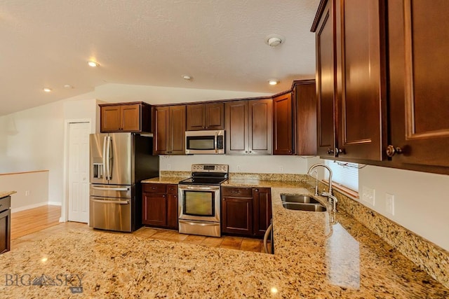25 Amber, Dillon, MT 59725 - kitchen featuring stainless steel appliances, a sink, vaulted ceiling, and light stone counters