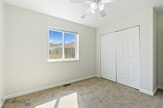 unfurnished bedroom featuring a closet, ceiling fan, and light carpet