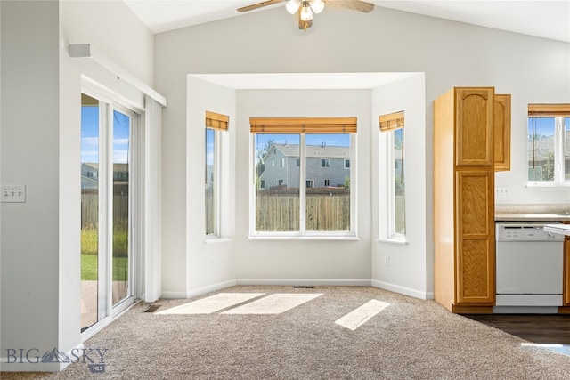 unfurnished dining area featuring lofted ceiling, ceiling fan, and dark carpet