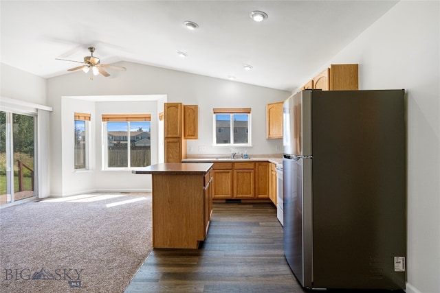 kitchen with a center island, lofted ceiling, stainless steel fridge, dark hardwood / wood-style floors, and ceiling fan